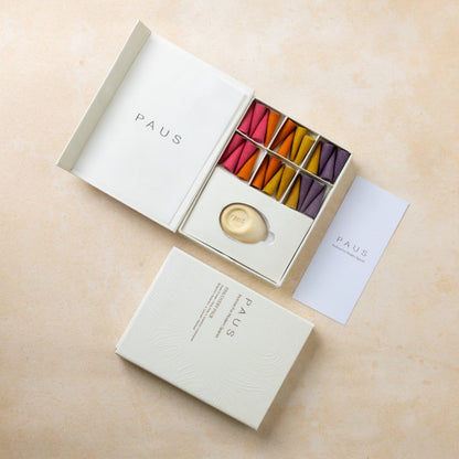 PAUS mood-enhancing incense product packaging with colorful incense on a beige surface