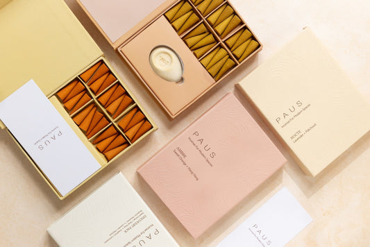 PAUS brand products including boxes and containers on a beige background